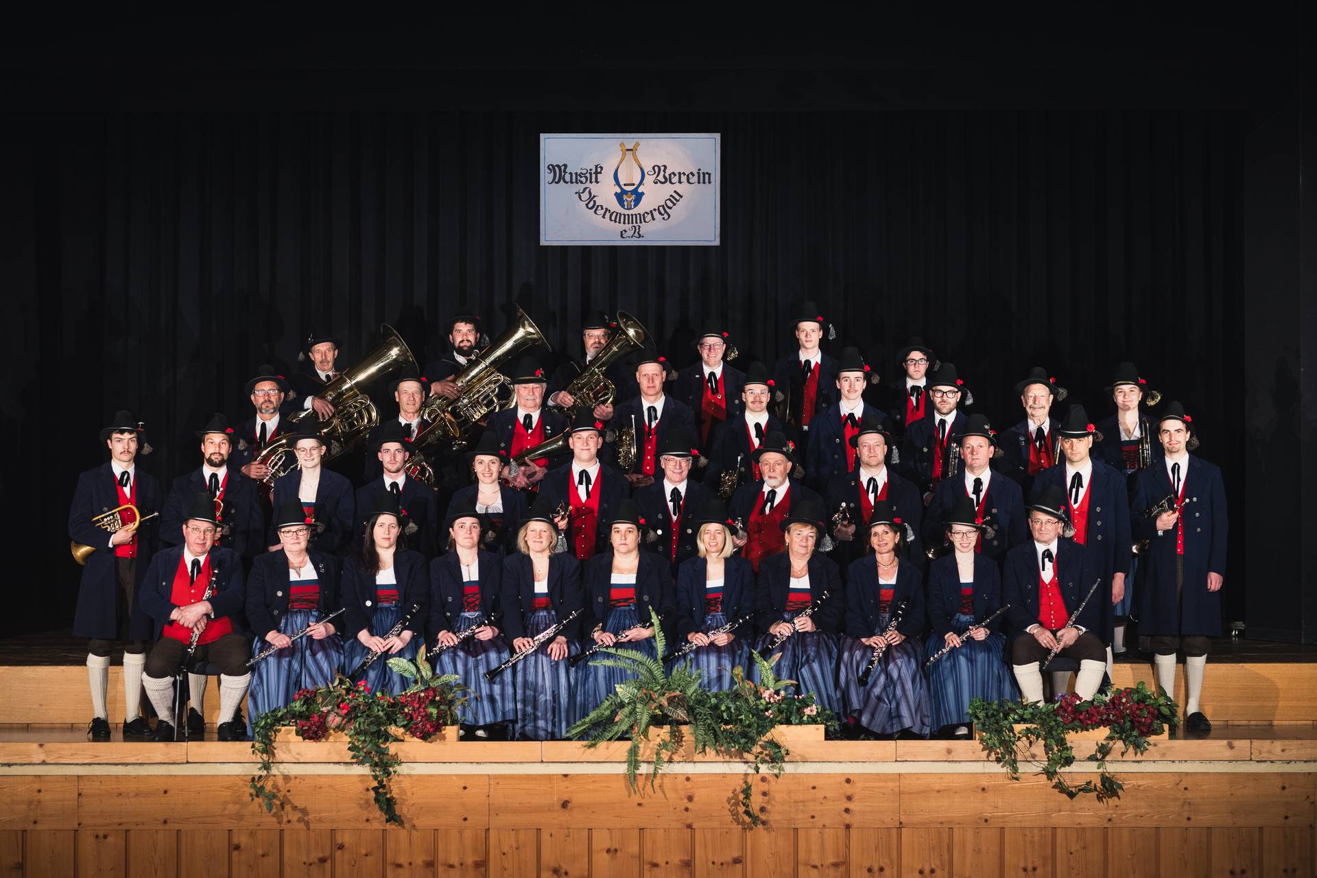 Die Blasmusik Oberammergau e.V. in traditioneller bayerischer Tracht vor einer Bergkulisse